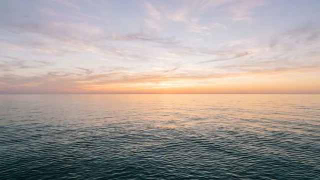 The open Gulf of Mexico at sunrise, calm water meeting a low horizon offshore of the Texas coast